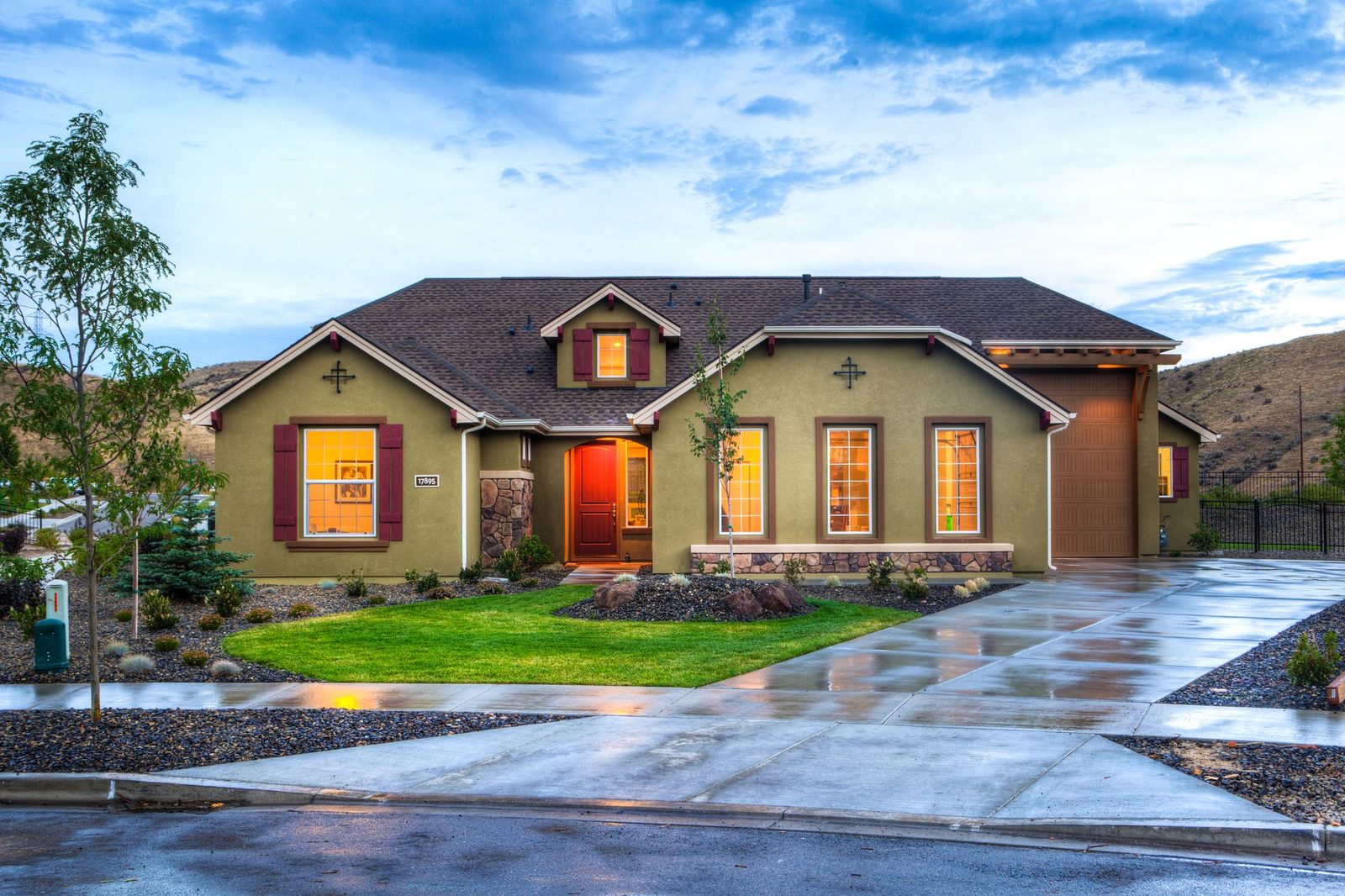 A brick house with a smart red front door at dusk
